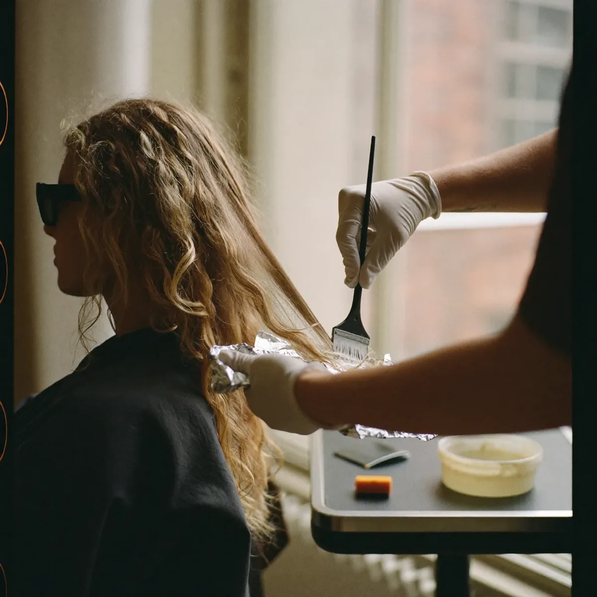 Colour being painted onto a section of curly hair
